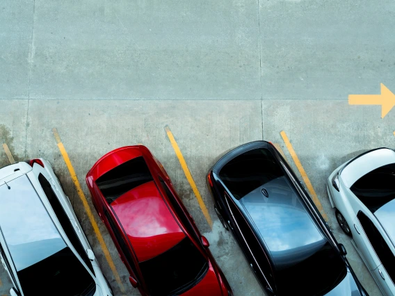 Overhead view of 4 cars parked diagonally in a parking lot.