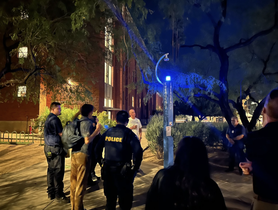 Vice President and Chief Safety Officer Steve Patterson gathers students and staff outside of the Modern Languages building to demonstrate emergency procedures using the Blue Light Emergency Phone.