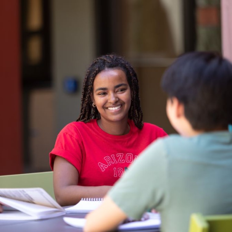 Smiling girl sitting at table having a conversation.