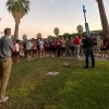 A group of students on a Safety Stroll are standing near a blue light phone on campus. Chief Olson is speaking with them.